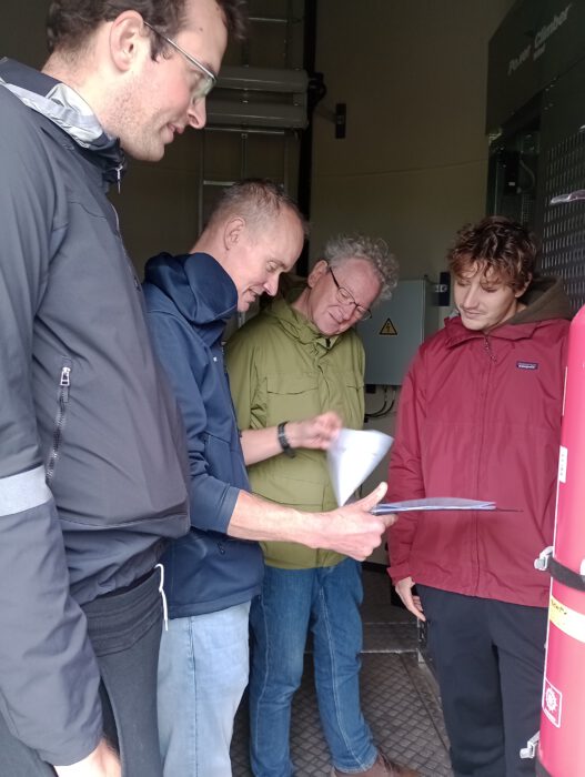 Molenaar Henri Spijkerman legt in de molen uit hoe alles werkt.